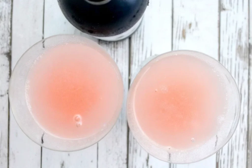 shake-and-strain-chilled-pink-lemon-drop-into-prepared-martini-glasses-