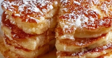Delicious apple yogurt pancakes stacked with syrup on top