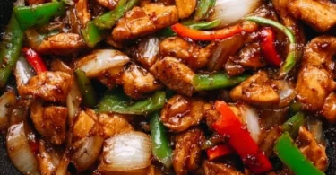 Plate of flavorful black pepper chicken with vegetables and rice