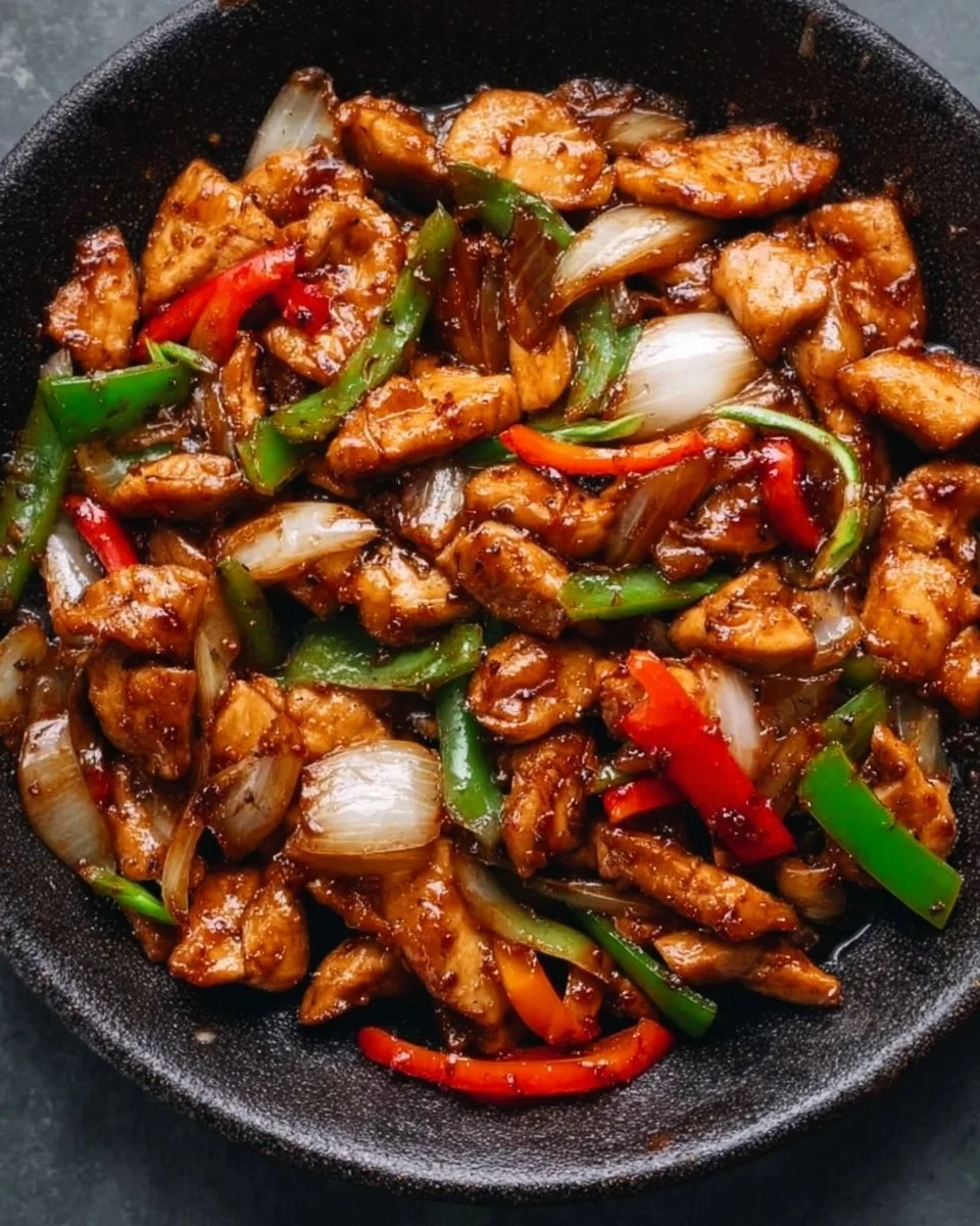 Plate of flavorful black pepper chicken with vegetables and rice
