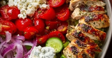 Healthy Greek Chicken Bowl with fresh vegetables and tzatziki sauce