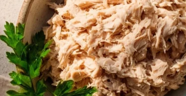 A bowl of vegan tuna salad made with chickpeas and seaweed, garnished with herbs.