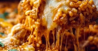 Delicious chicken enchilada rice casserole topped with cheese and herbs.