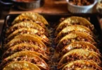 Crispy ground beef tacos garnished with fresh vegetables and cheese