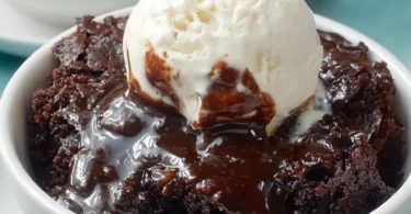 Delicious Crockpot Brownies Pudding in a bowl, topped with chocolate sauce