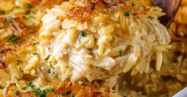 Savory French Onion Chicken Orzo Casserole topped with melted cheese and herbs.