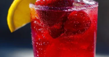 A refreshing glass of Hibiscus Tea Strawberry-Lemonade with mint garnish.