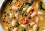 Bowl of high protein white bean soup garnished with herbs