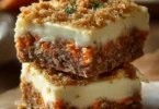 Irresistibly indulgent carrot cake cream cheese bars with frosting on a plate.