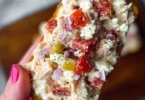 Bowl of Italian Grinder Chicken Salad with fresh vegetables and dressing