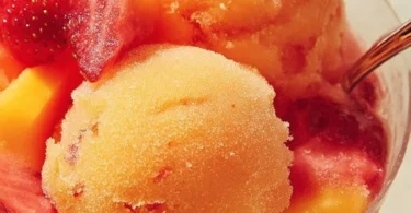 A bowl of vibrant mango strawberry sorbet served on a sunny day.