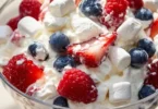 Delicious Red White and Blue Cheesecake Salad with fresh berries and creamy dressing.