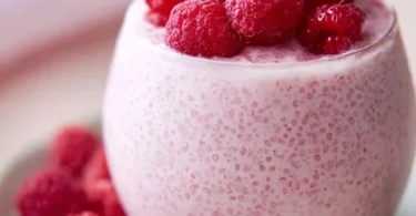 Vanilla Raspberry Chia Pudding in a glass bowl with fresh raspberries